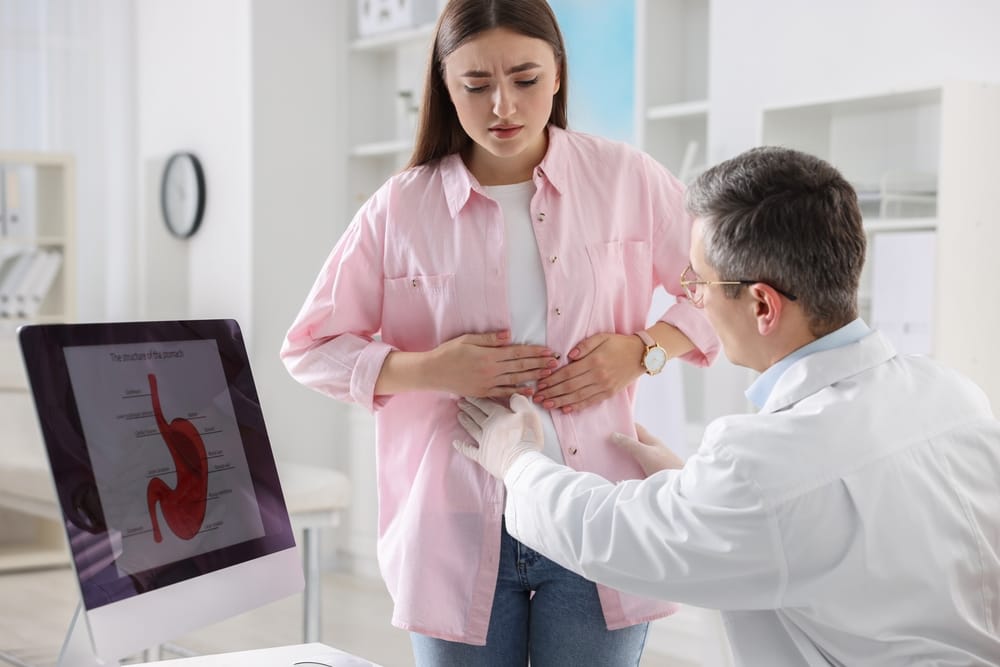 Gastroenterologist,Examining,Patient,With,Stomach,Pain,In,Clinic